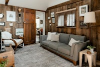 a living room with wood paneling and a couch